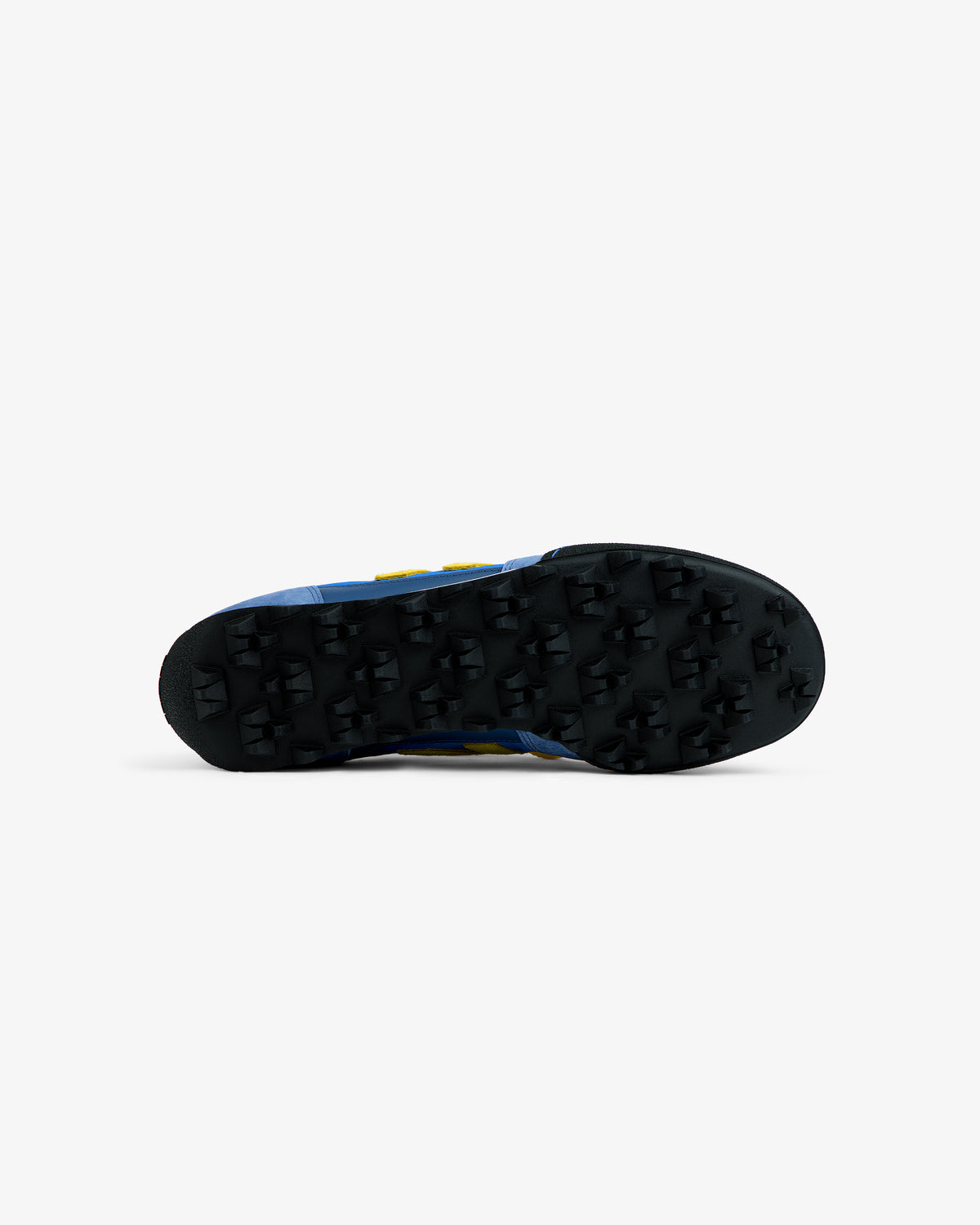 Bottom view of an ALD / New Balance Gator sneaker with a blue upper and a black, cleated rubber sole.