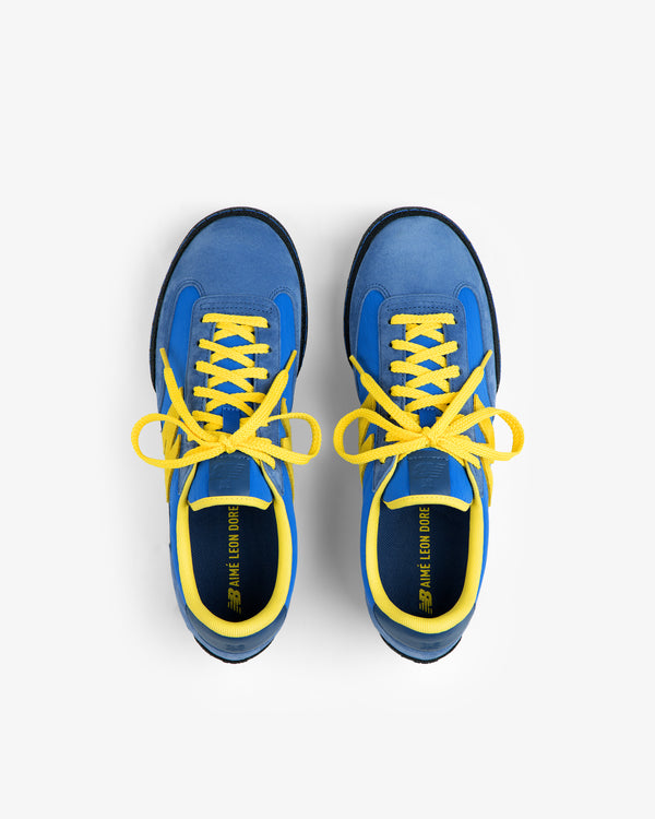 Top-down view of ALD / New Balance Gator sneakers in blue with yellow laces and trim.