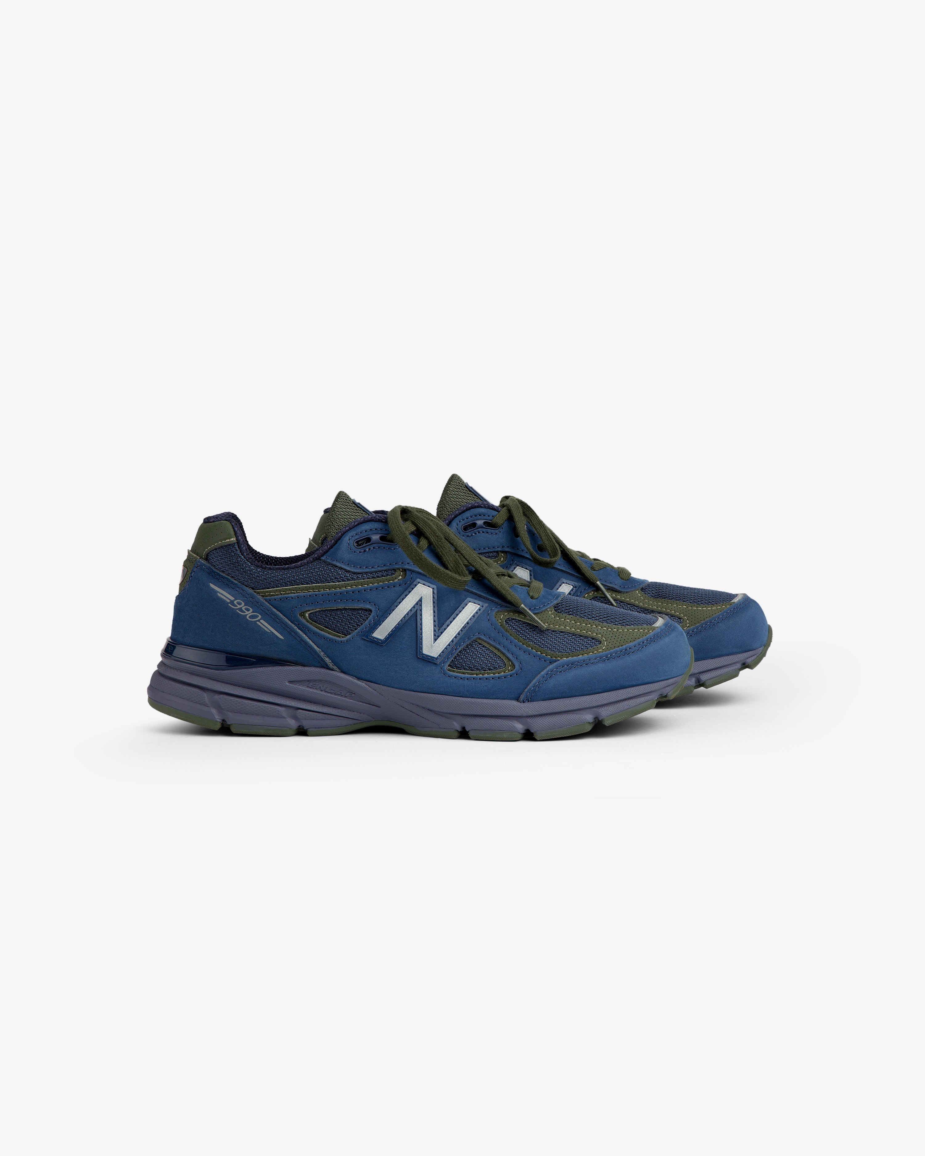 New Balance Made in USA 990v4 sneakers in blue with gray soles and laces, angled on a white background.