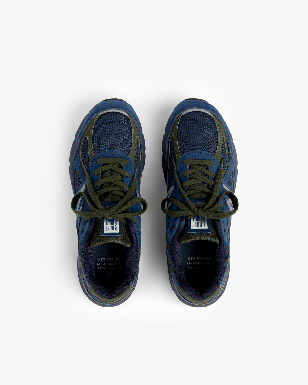 Blue and green New Balance Made in USA 990v4 sneakers with laces, top view on a white background.