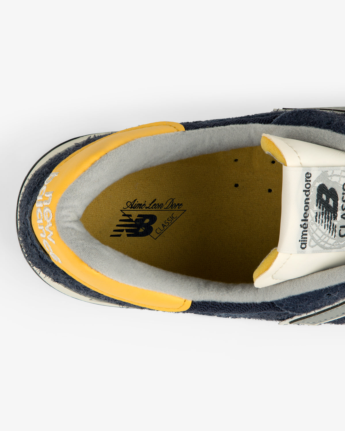 Top view of ALD / New Balance Made in USA 1300 sneaker with yellow accents and Aimé Leon Dore branding.