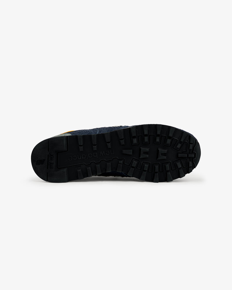 Black rubber sole of ALD / New Balance Made in USA 1300 shoe viewed from bottom, showing tread pattern and logo.
