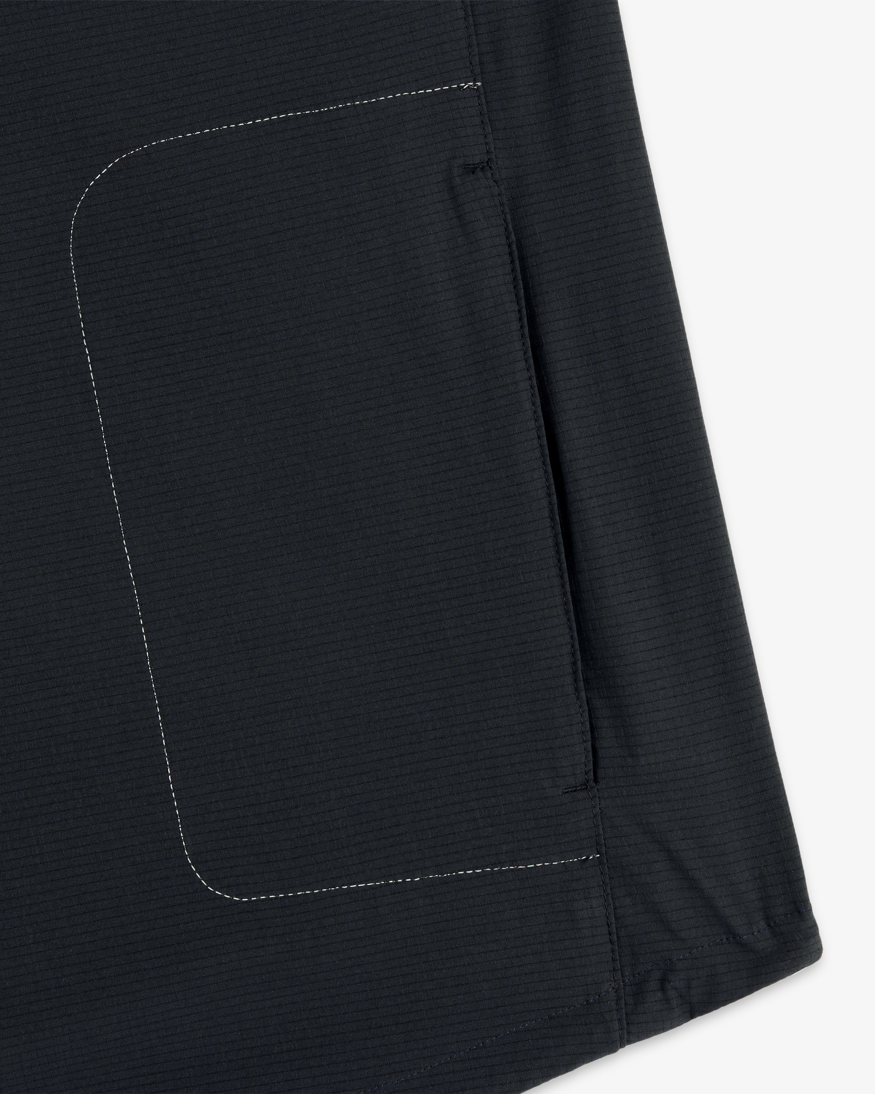 Close-up of the ALD / New Balance Performance Nylon Jacket showing side seam, white stitching, and pocket detail.