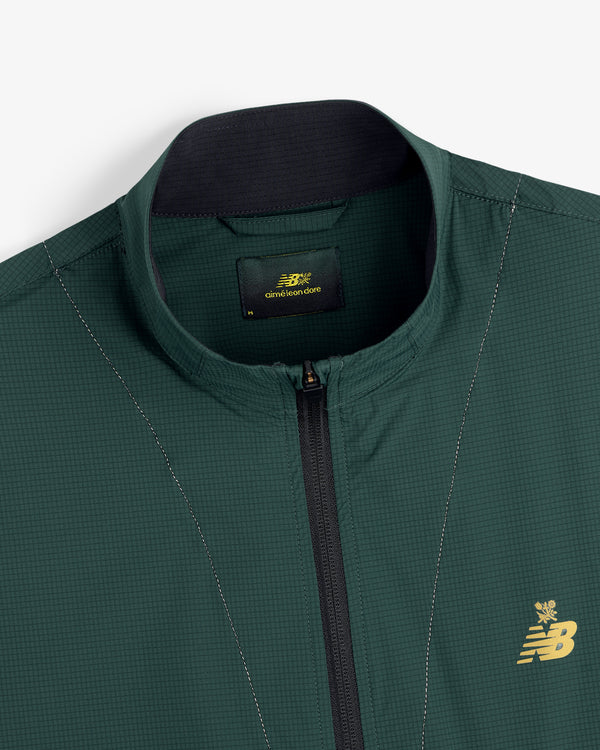 Close-up of a green ALD / New Balance Performance Nylon Jacket with zip front and gold chest logo.
