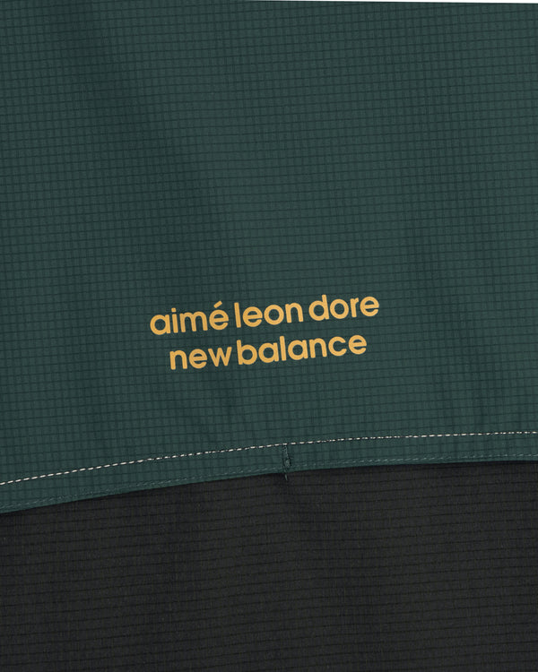 Close-up of green and black ALD / New Balance Performance Nylon Jacket with yellow printed text.