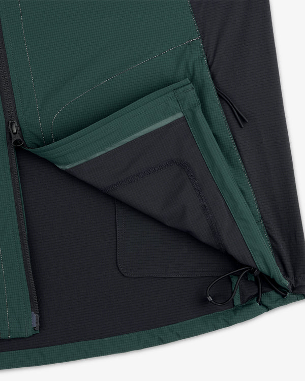 Close-up of the ALD / New Balance Performance Nylon Jacket showing an open zippered pocket and hem drawstring.