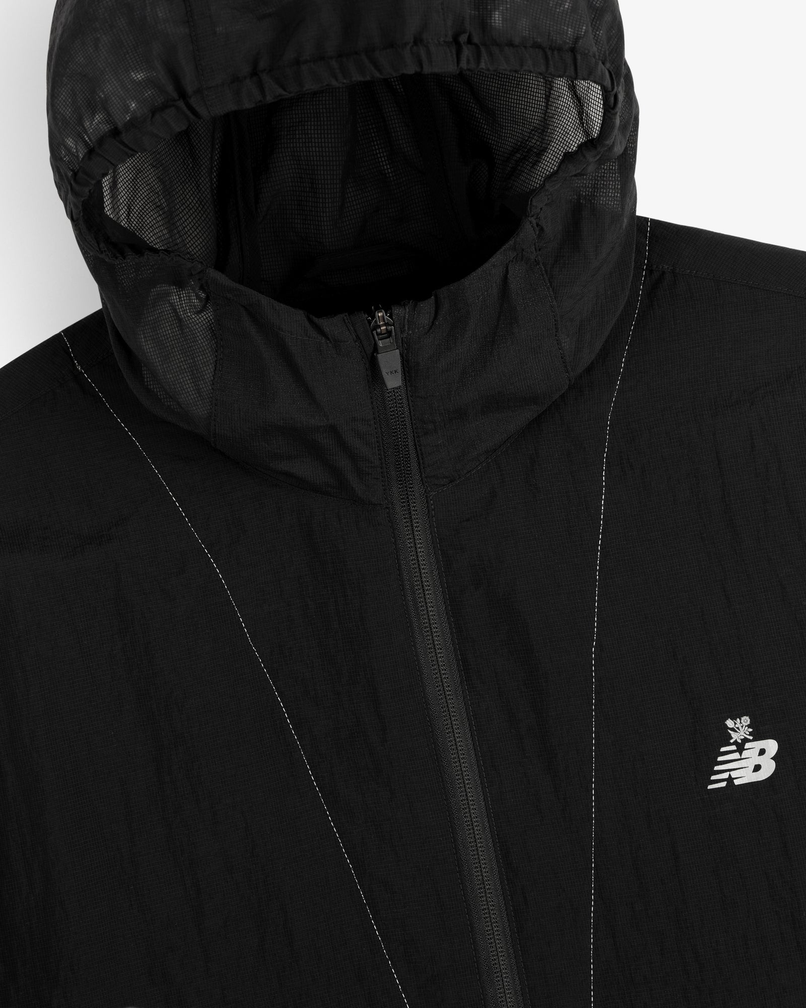 Close-up of a black ALD / New Balance Breathable Half-Zip Pullover with a visible zipper and chest logo.