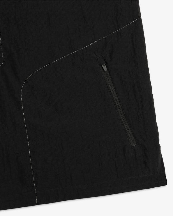 Close-up of ALD / New Balance Breathable Half-Zip Pullover with black fabric, zipper pocket, and white stitching.