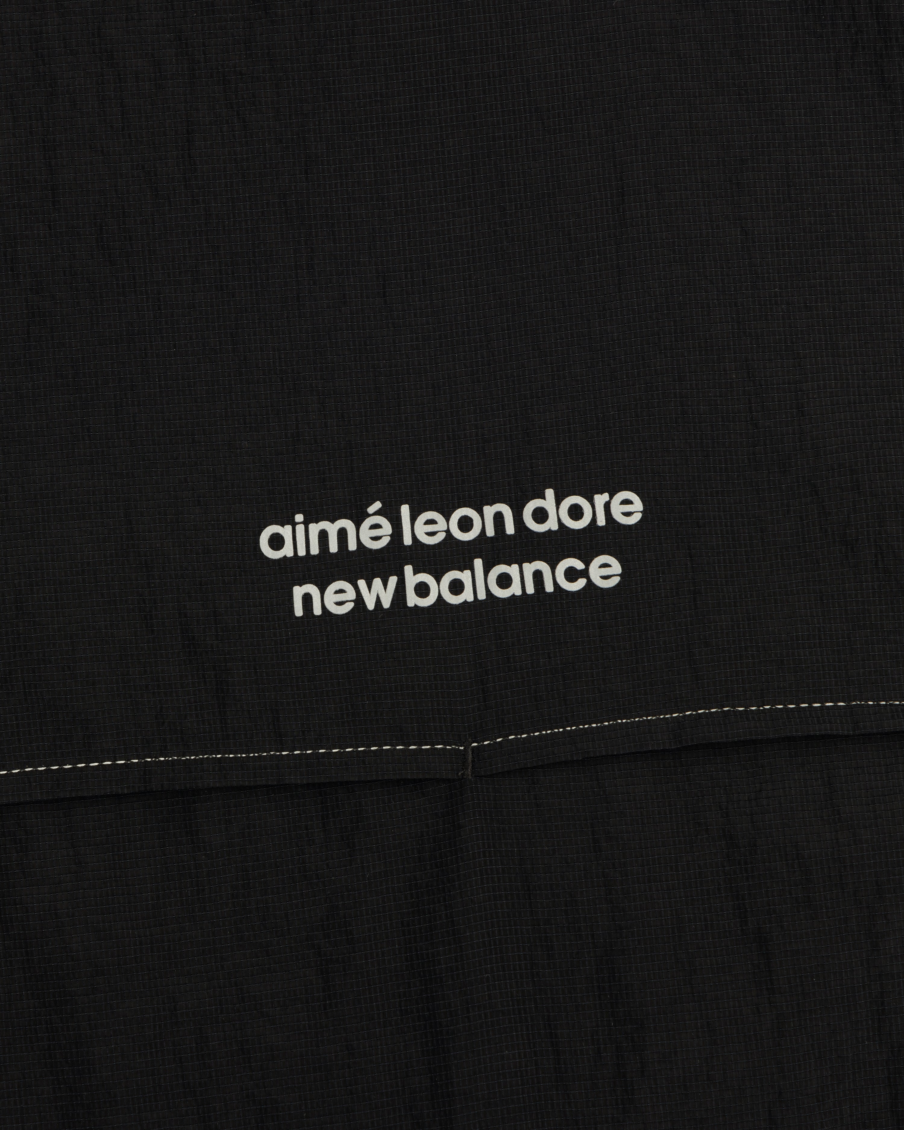 Black ALD / New Balance Breathable Half-Zip Pullover with white logo text and a visible stitched seam below.