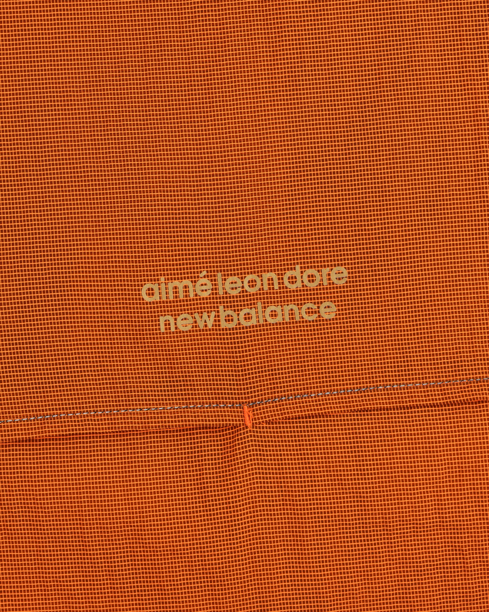 Orange textured ALD / New Balance Breathable Half-Zip Pullover with light yellow logo at the center.