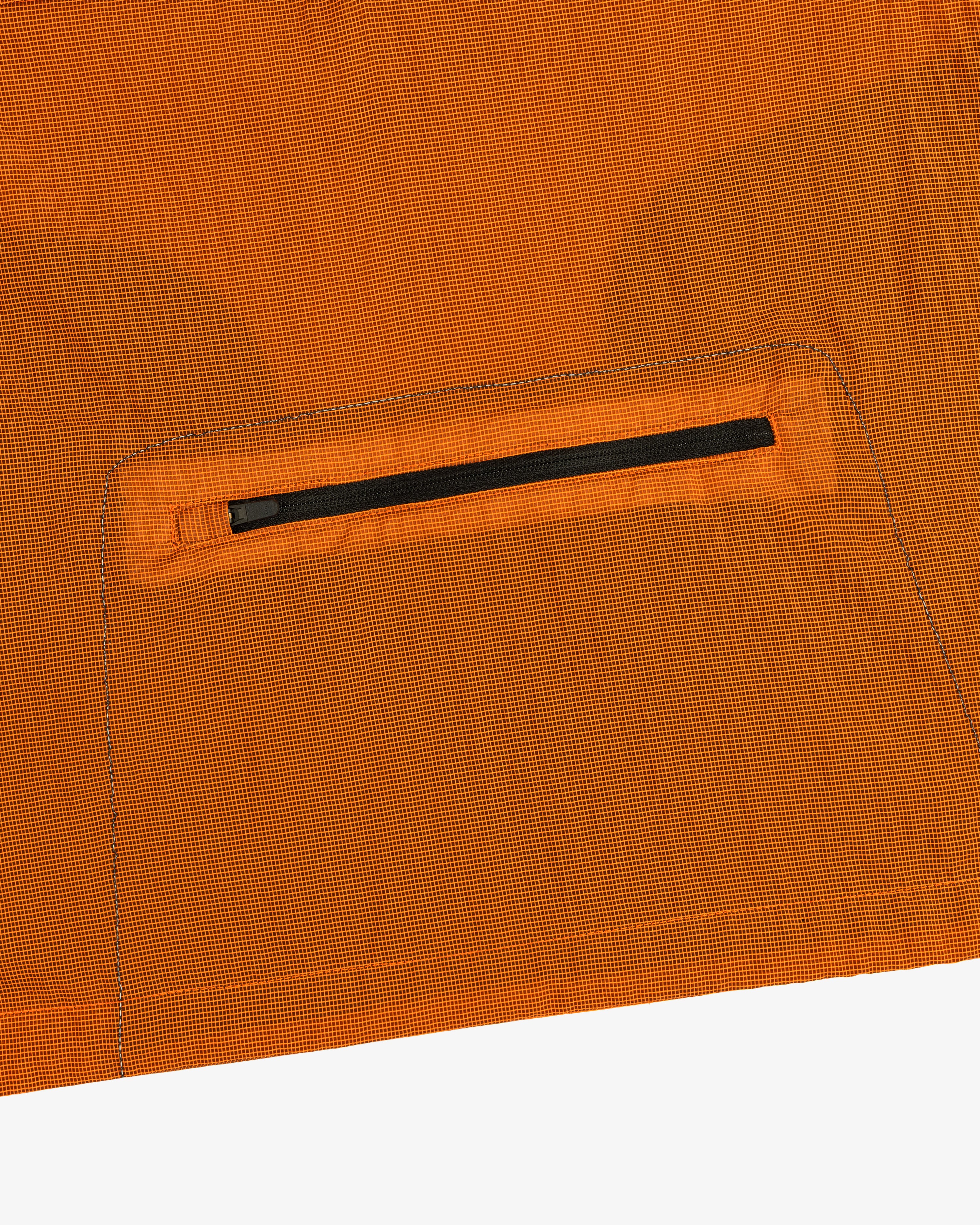 Close-up of the ALD / New Balance Breathable Half-Zip Pullover’s orange ripstop fabric with a black zip pocket.