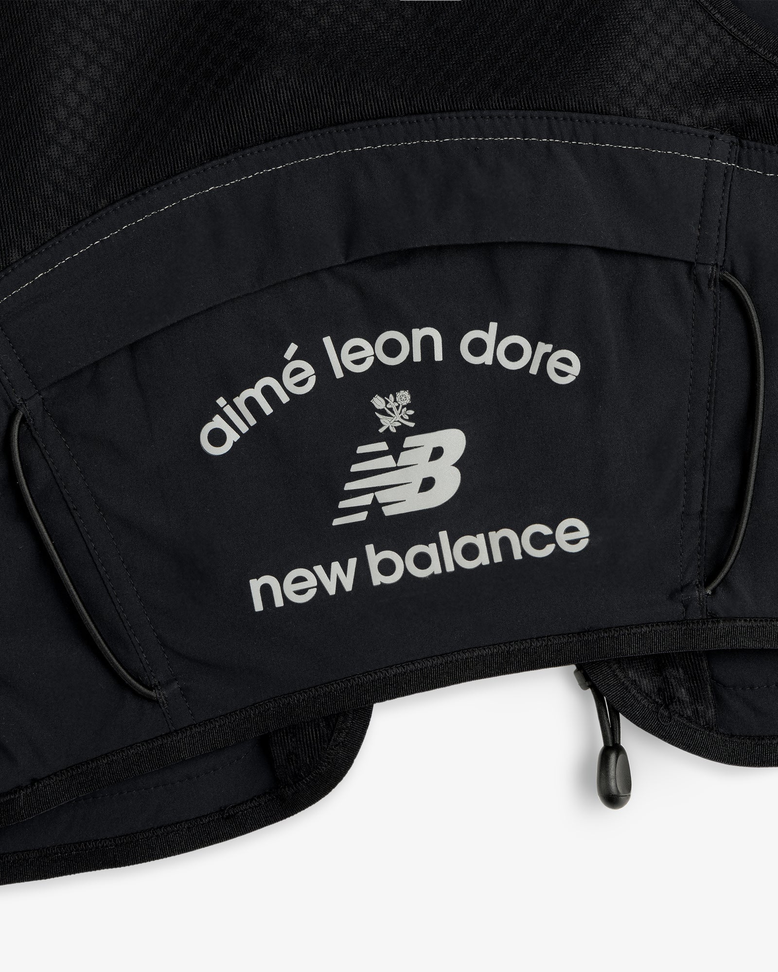 Close-up of black fabric from the ALD / New Balance Hydrovest with white Aimé Leon Dore and NB logos.