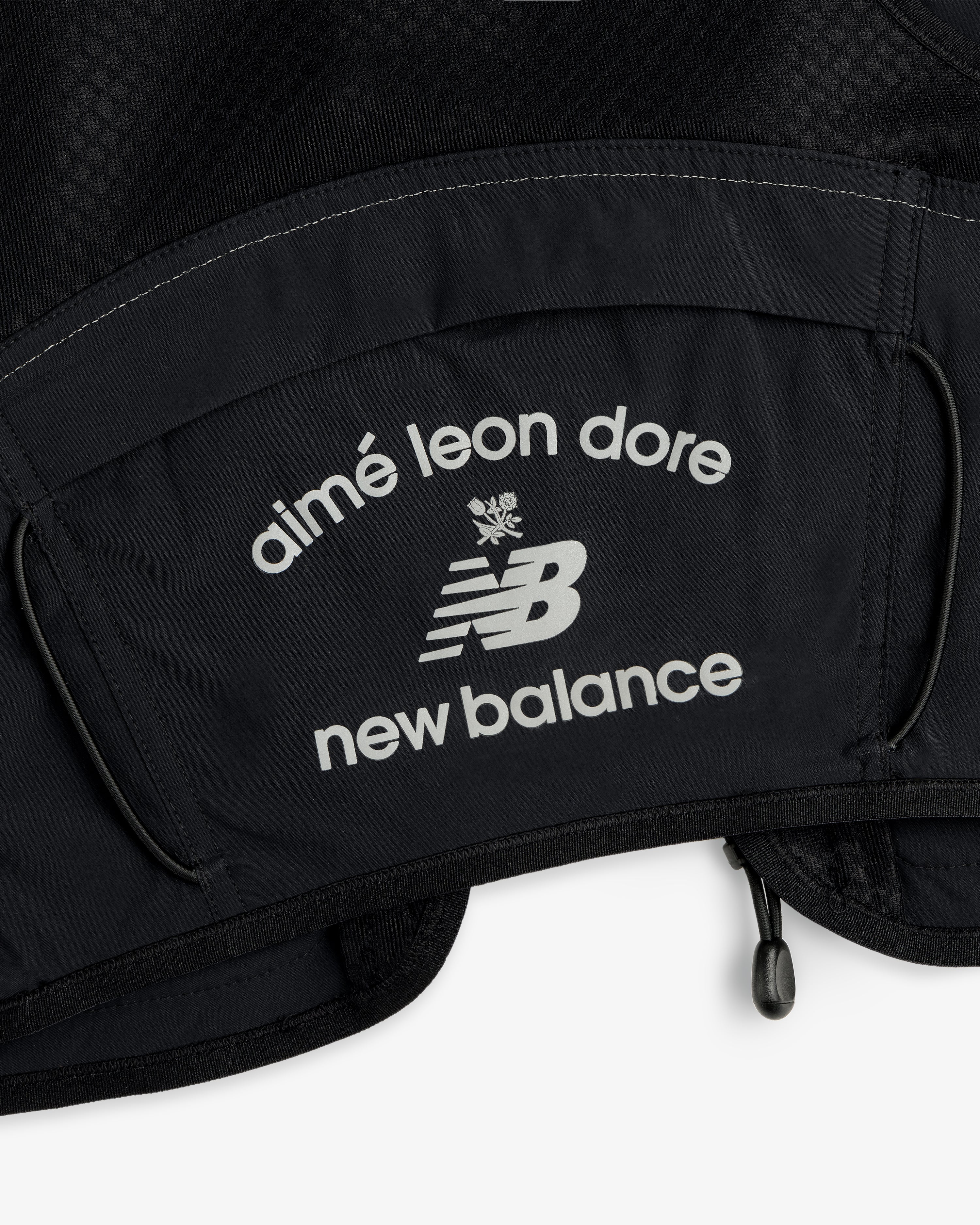 Close-up of black fabric from the ALD / New Balance Hydrovest with white Aimé Leon Dore and NB logos.