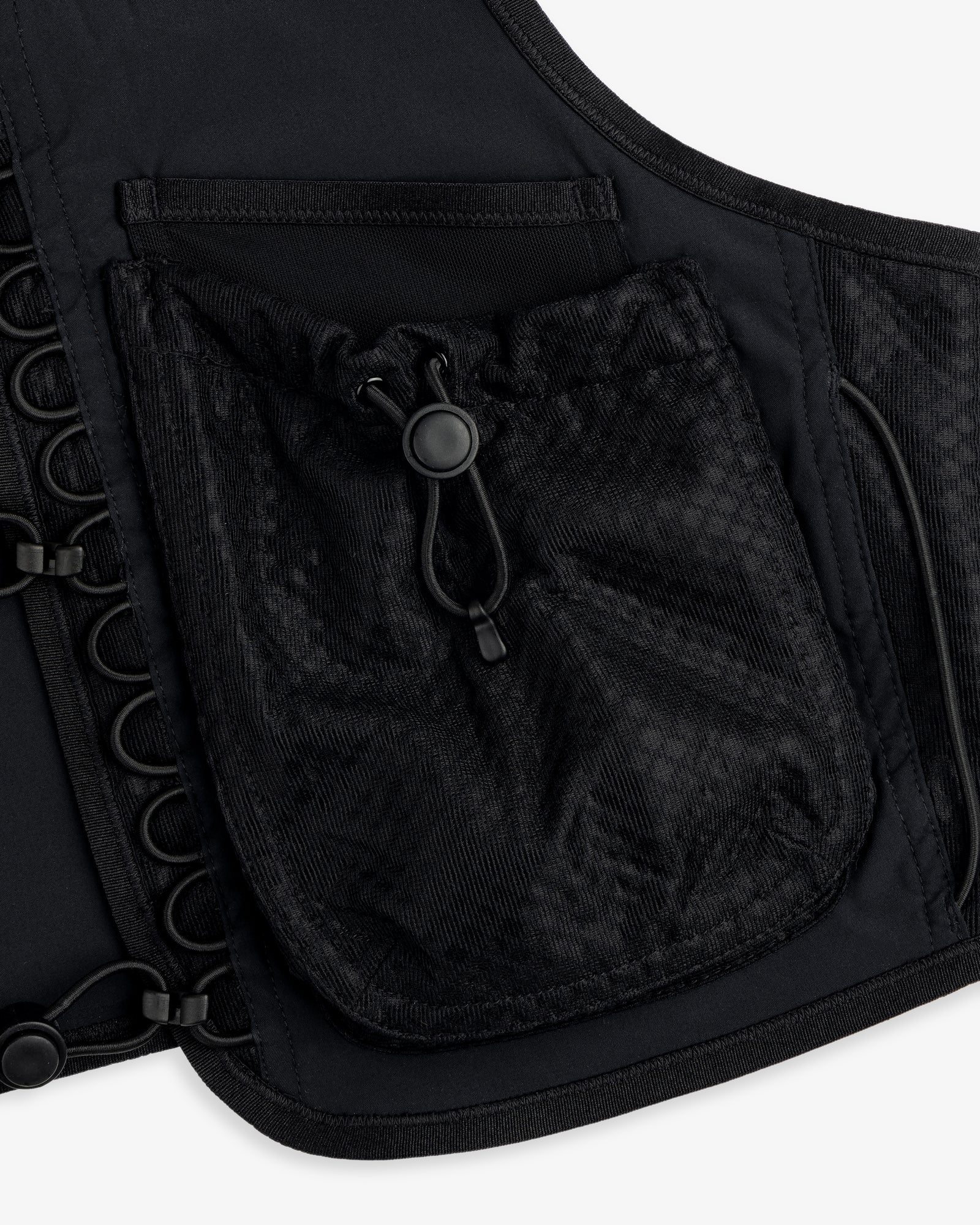 Close-up of the ALD / New Balance Hydrovest, a black vest with mesh drawstring pocket and side grommet details.