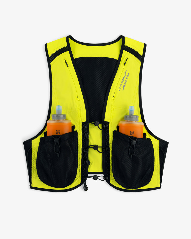 The ALD / New Balance Hydrovest is yellow and black with two orange water bottles in front pockets, shown on white.