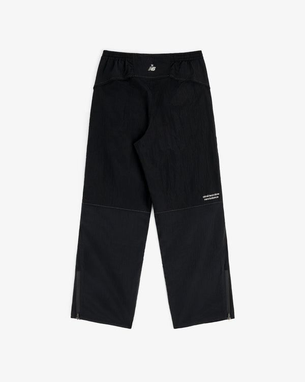 ALD / New Balance Lightweight Nylon Warmup Pant in black with subtle texture, white logo, and zippered ankles.