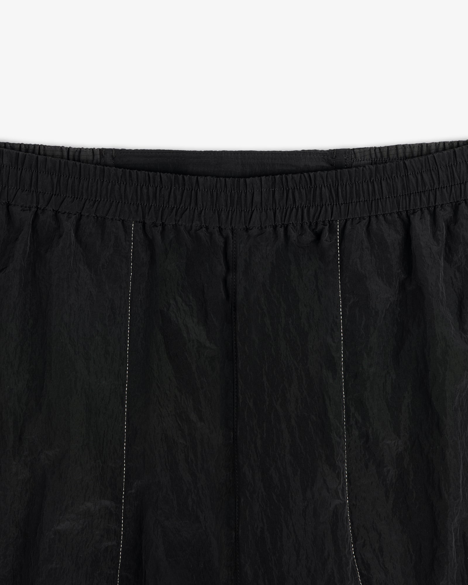 Close-up of ALD / New Balance Lightweight Nylon Warmup Pant in black with elastic waistband and white stitching.