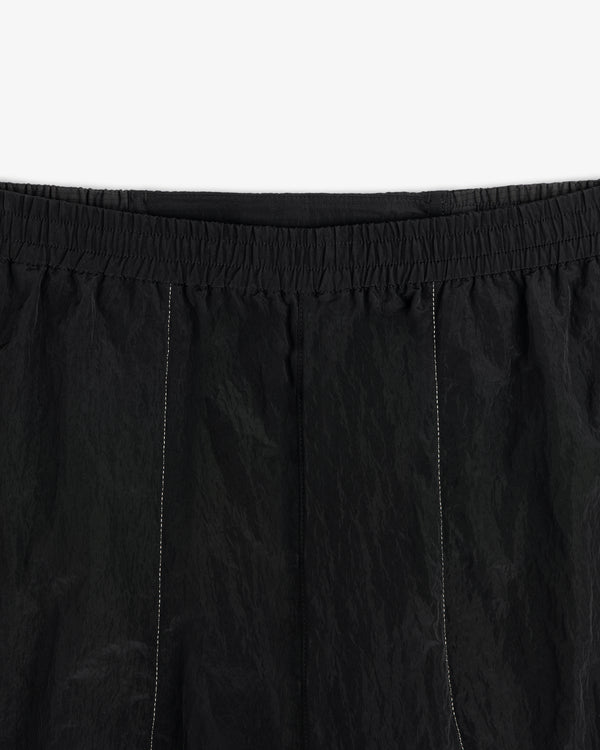 Close-up of ALD / New Balance Lightweight Nylon Warmup Pant in black with elastic waistband and white stitching.