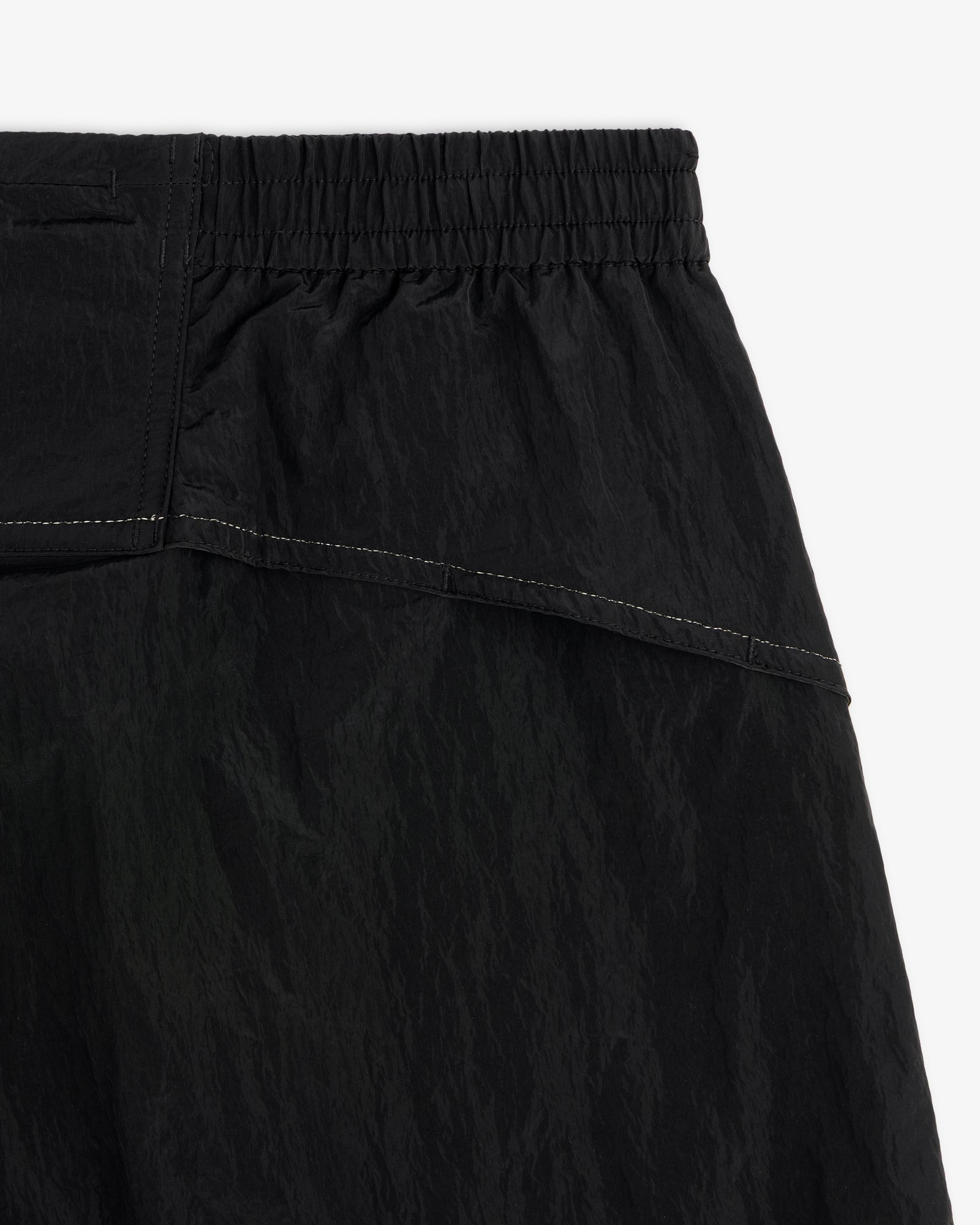 Close-up of ALD / New Balance Lightweight Nylon Warmup Pant in black with elastic waistband and white stitching.