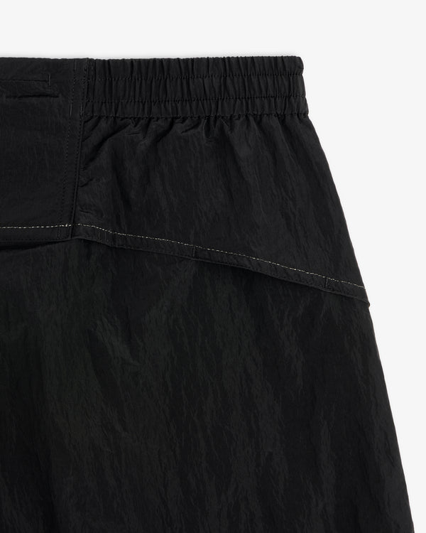Close-up of ALD / New Balance Lightweight Nylon Warmup Pant in black with elastic waistband and white stitching.