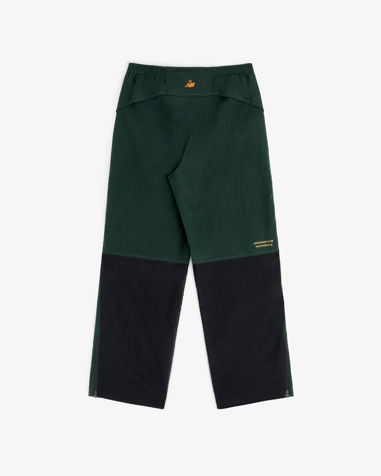ALD / New Balance Lightweight Nylon Warmup Pant in dark green/black with relaxed fit, zippered hems, yellow back logo.