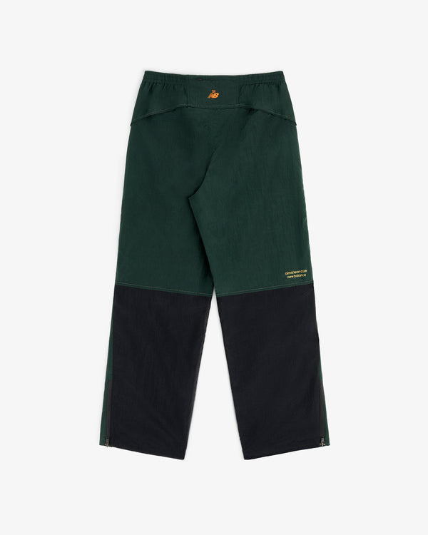 ALD / New Balance Lightweight Nylon Warmup Pant in dark green/black with relaxed fit, zippered hems, yellow back logo.