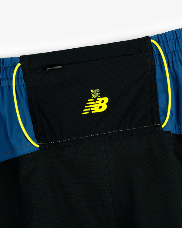 Close-up of ALD / New Balance Performance Lightweight Running Short in black and blue with yellow logo and trim.