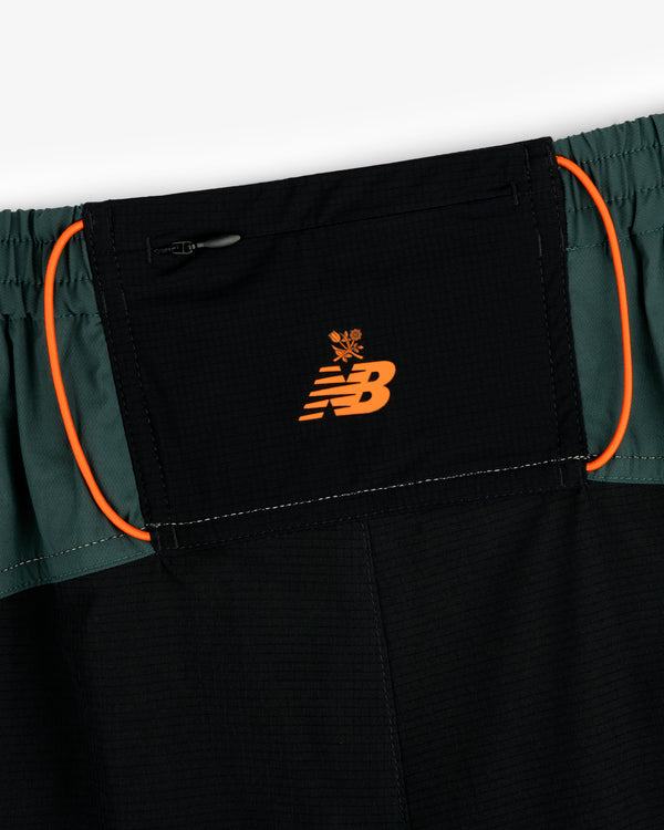 Close-up of ALD / New Balance Performance Lightweight Running Short in black with orange logo and green side panels.