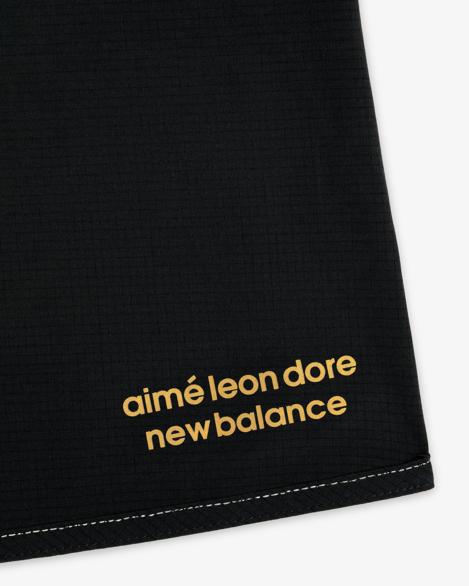 Black ALD / New Balance Performance Lightweight Running Short with yellow lowercase logo and white bottom stitching.