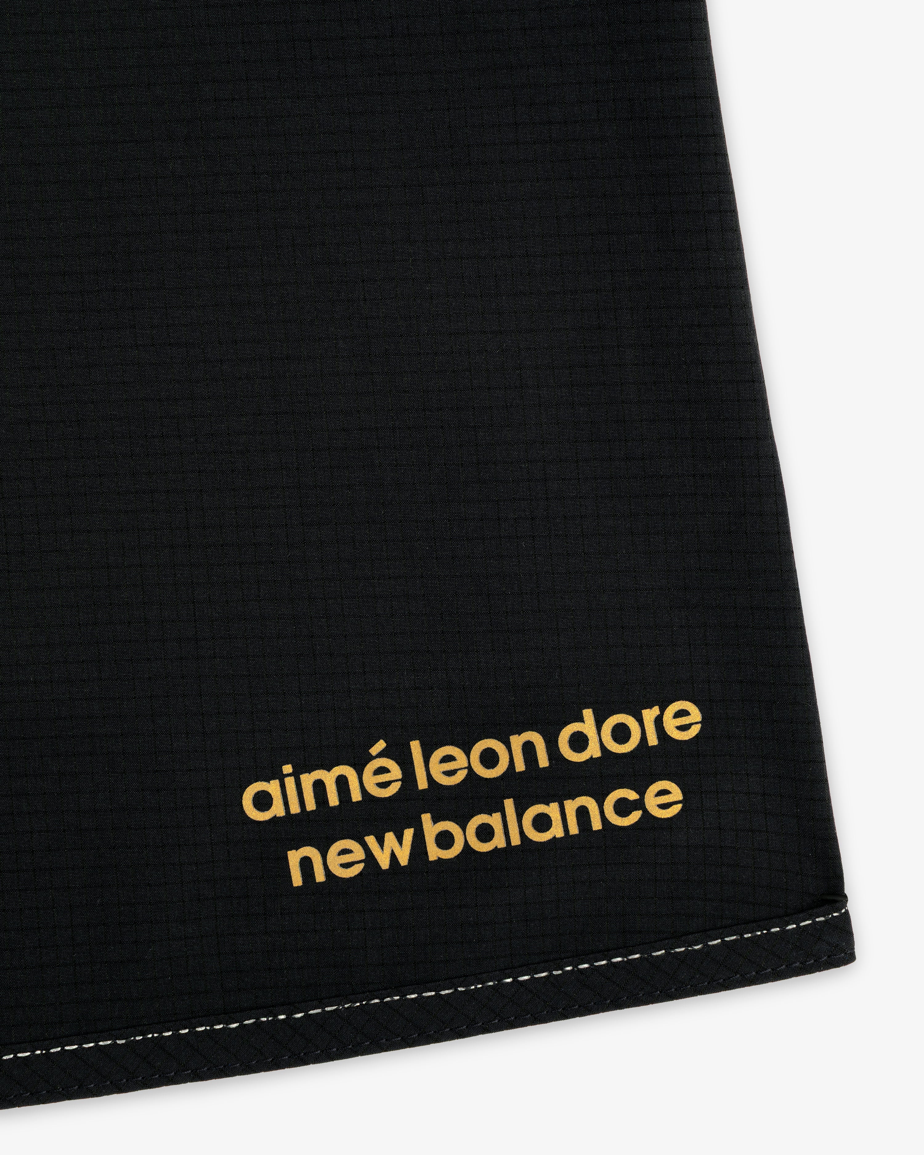 Black ALD / New Balance Performance Lightweight Running Short with yellow lowercase logo and white bottom stitching.