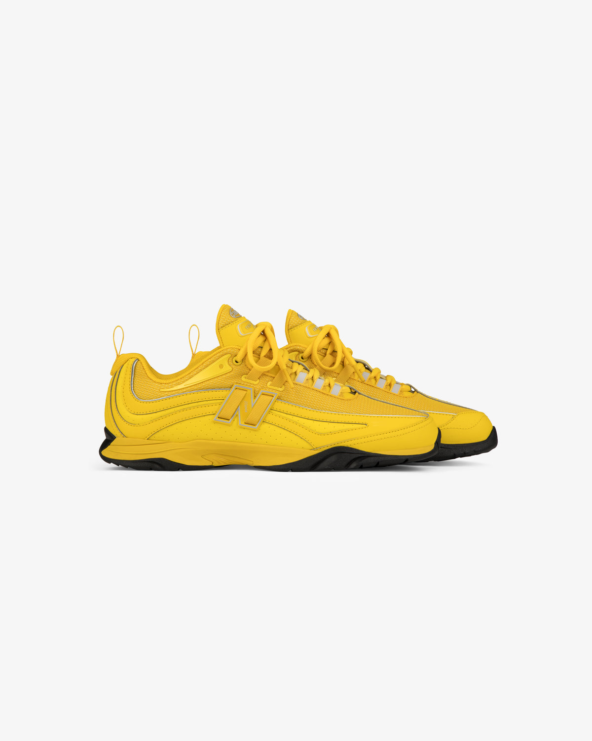 ALD / New Balance RC56 sneakers in bright yellow with bold N logo, black soles, and yellow laces on white background.