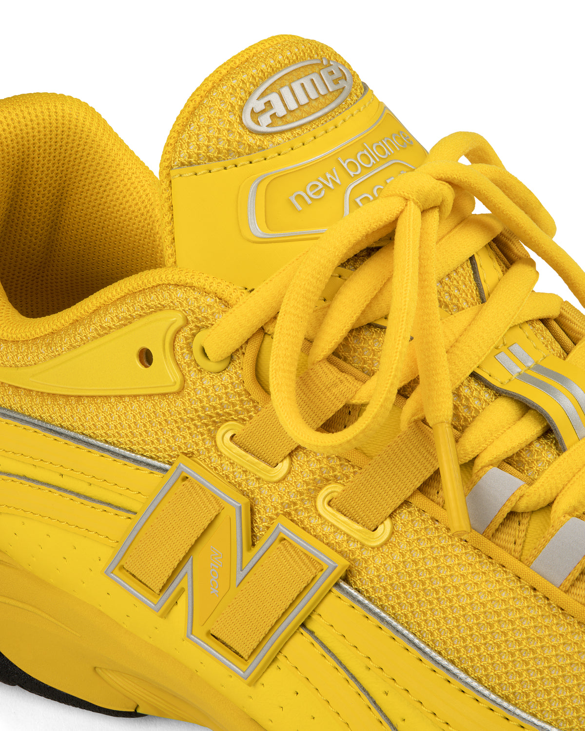 Close-up of an ALD / New Balance RC56 sneaker in yellow mesh and synthetic, laced up with a bold N logo on the side.