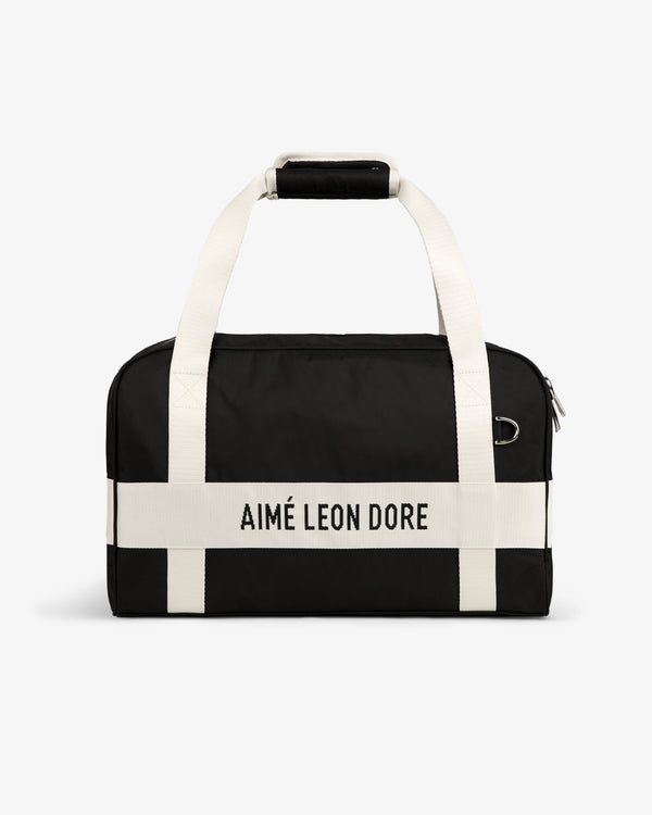 Nylon Duffle Bag in black with white handles and AIMÉ LEON DORE printed on a white front strap.