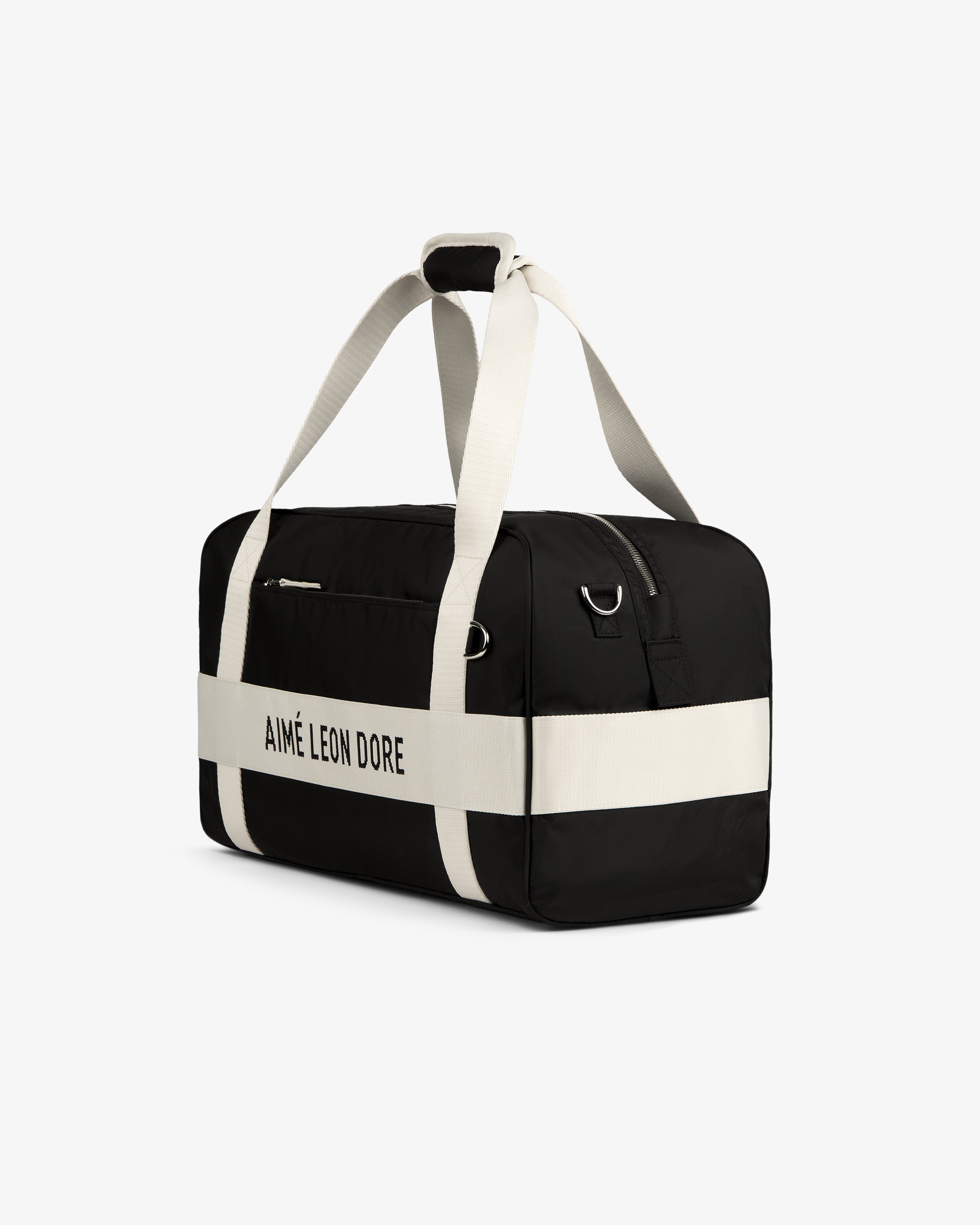 Black and white Nylon Duffle Bag with AIMÉ LEON DORE on the side and white straps, shown on a white background.