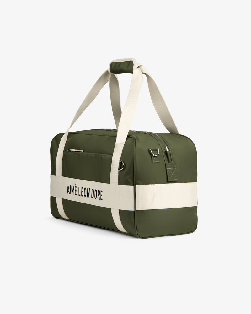 A green Nylon Duffle Bag with white straps and AIMÉ LEON DORE text, shown on a white background.