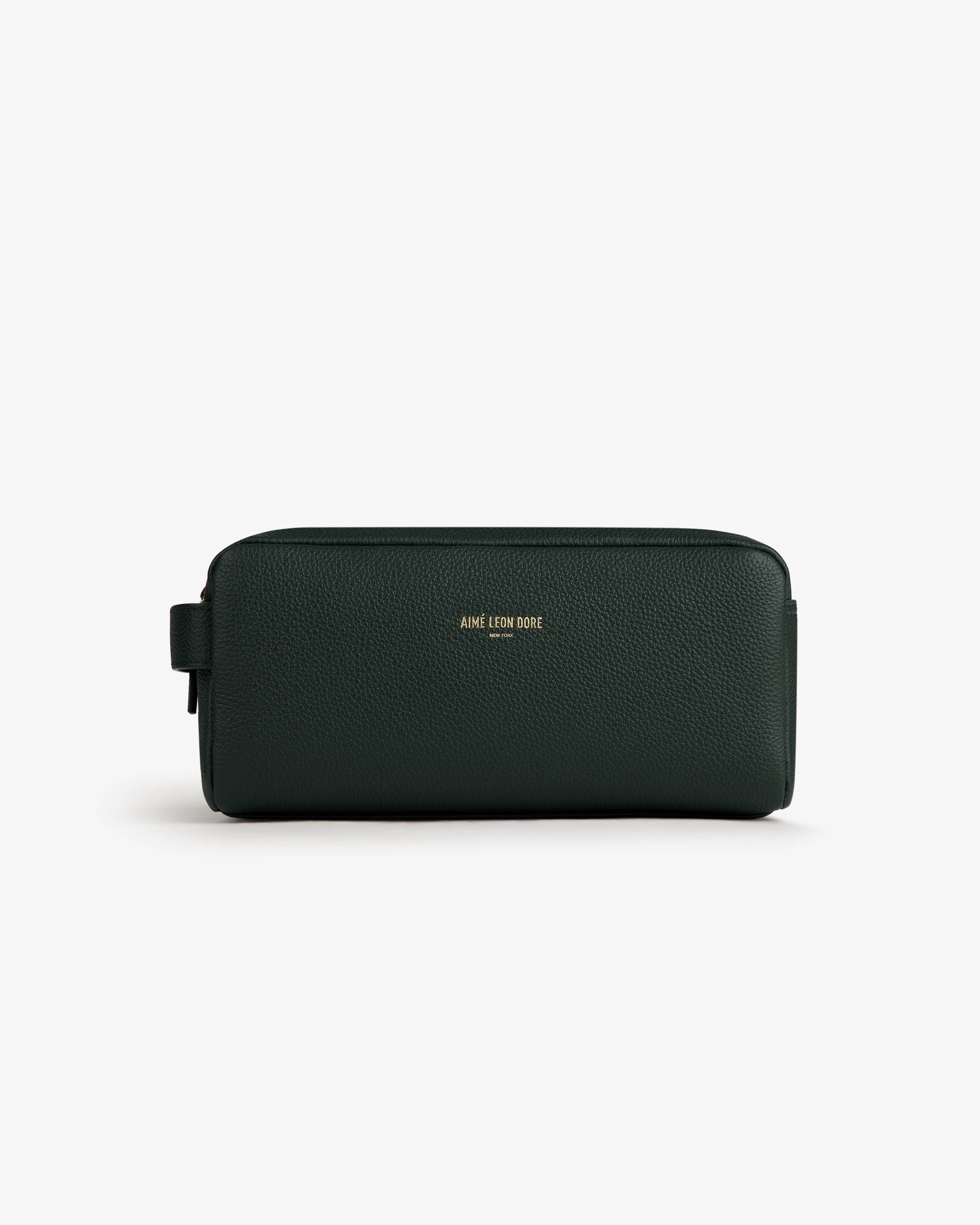 Dark green Leather Traveler Kit with gold AIMÉ LEON DORE branding, shown on a white background.
