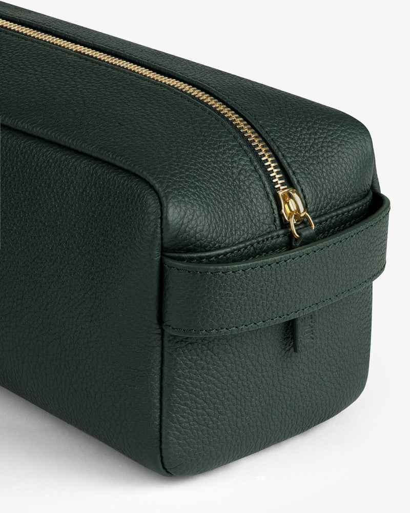 Leather Traveler Kit in dark green textured leather with gold zipper and side handle, displayed on white background.