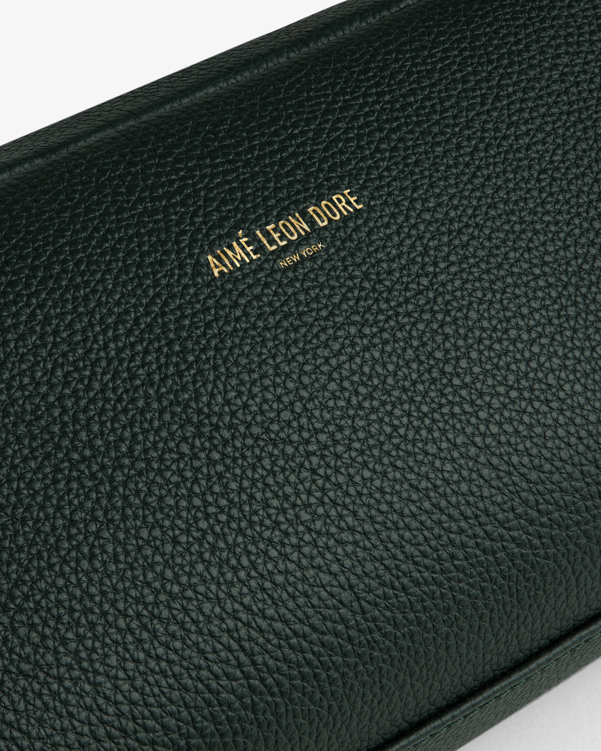 Close-up of the Leather Traveler Kit in black textured leather with AIMÉ LEON DORE NEW YORK embossed in gold.