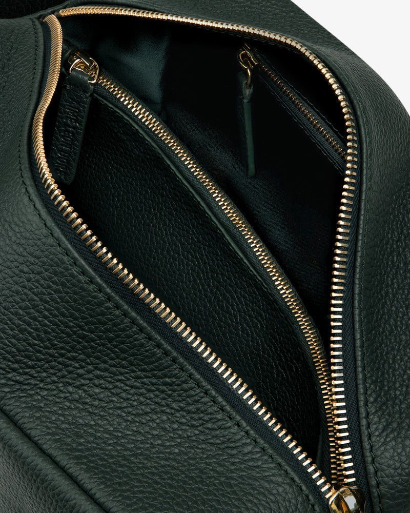 Close-up of the Leather Traveler Kit in black leather with gold zippers, featuring an open main compartment and inner pocket.