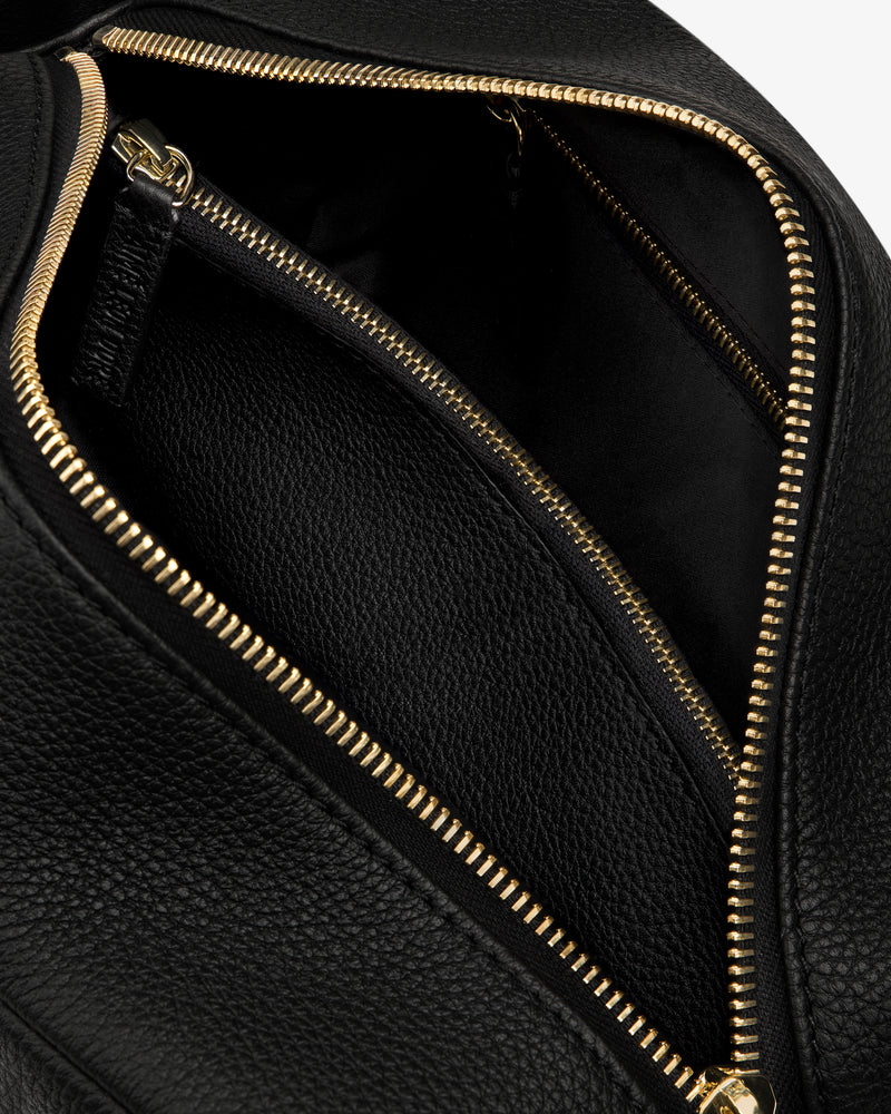 Close-up of the Leather Traveler Kit in black leather with gold zippers, showing the inside pocket and texture.