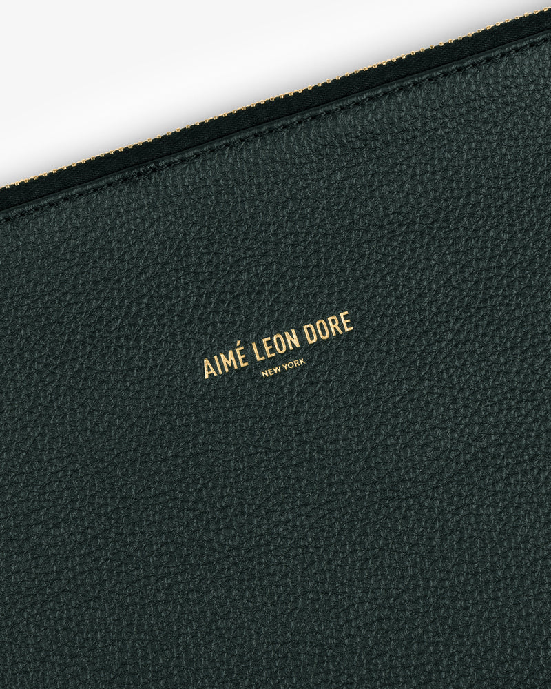 Close-up of textured dark green leather Small Leather Pouch with Aimé Leon Dore New York embossed in gold.