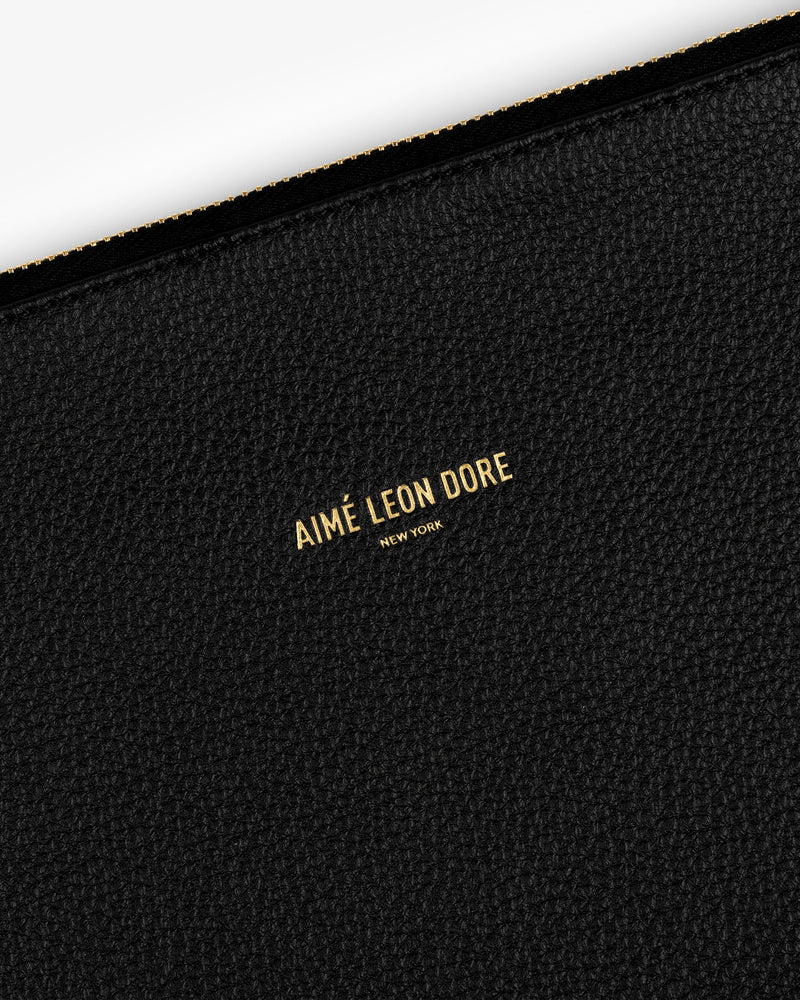 Black textured leather Small Leather Pouch with AIMÉ LEON DORE NEW YORK stamped in small gold letters at the center.
