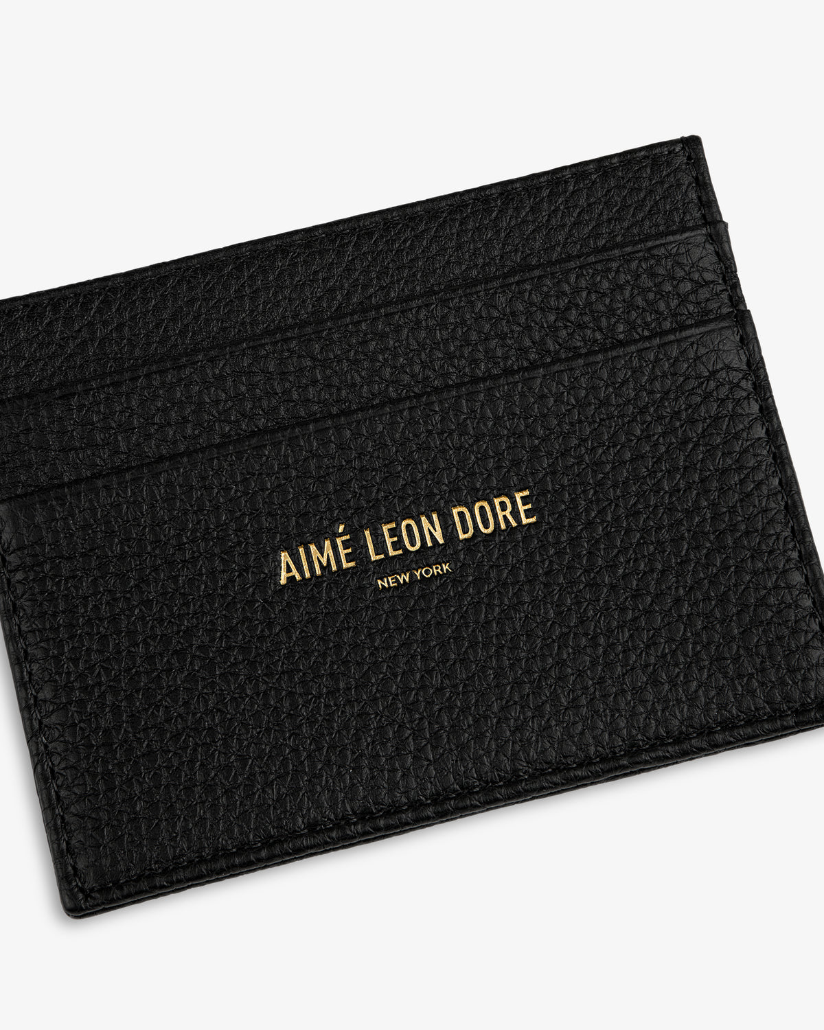 Leather Card Holder in black textured leather with AIMÉ LEON DORE NEW YORK gold lettering on the front.