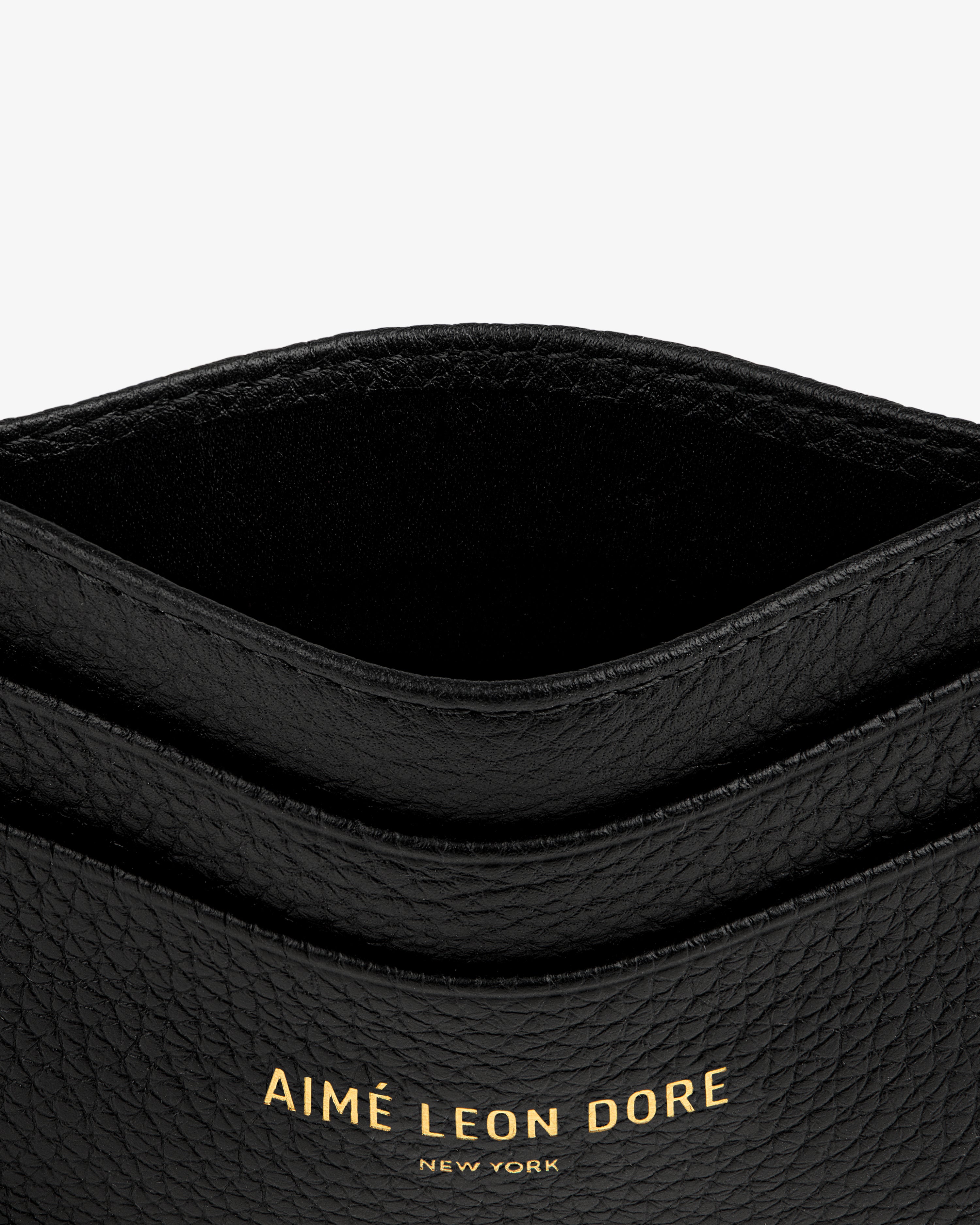 Close-up of the Leather Card Holder in black textured leather with gold AIMÉ LEON DORE NEW YORK lettering.
