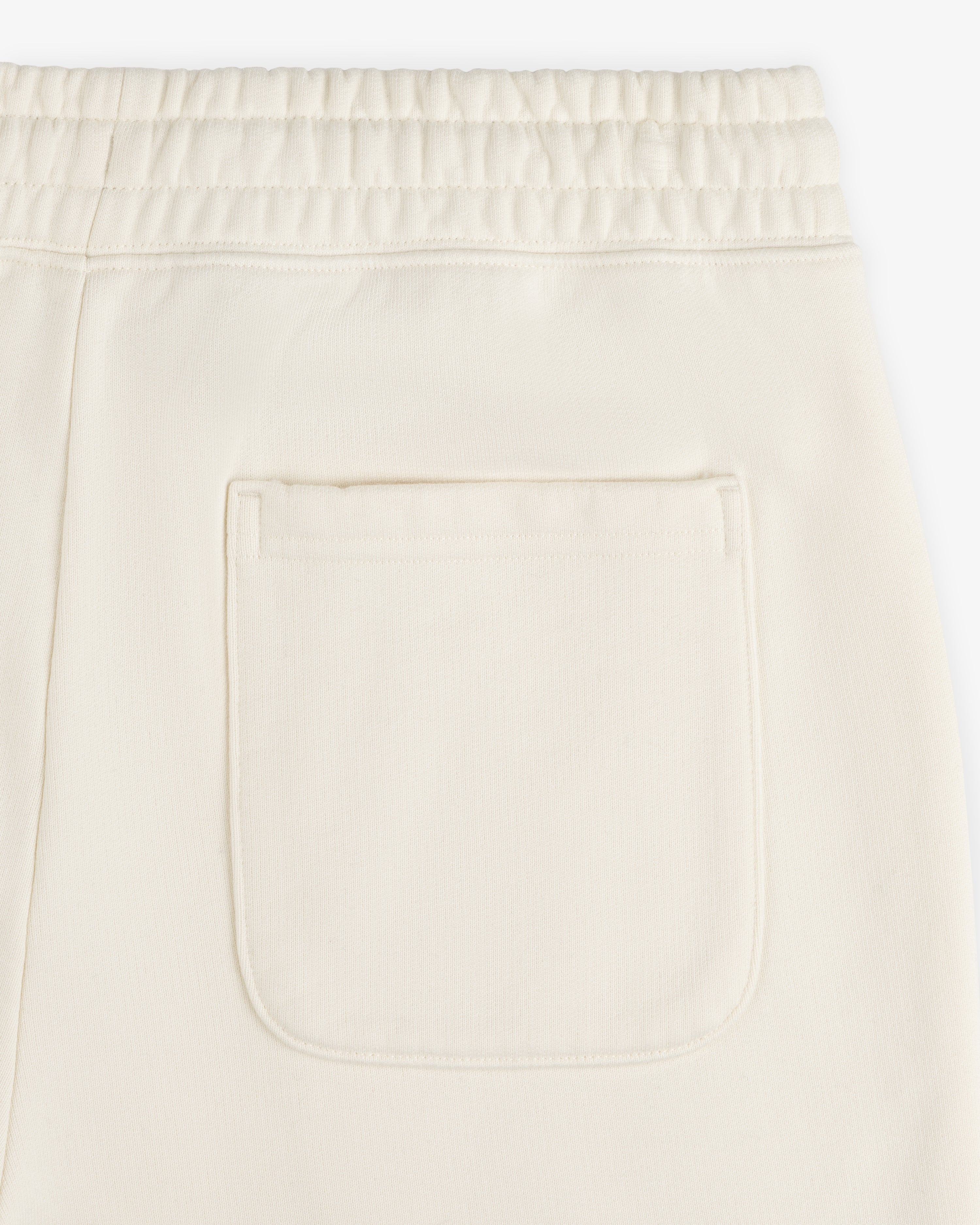 Close-up of Unisphere Sweatpants in cream with an elastic waistband and single back patch pocket.