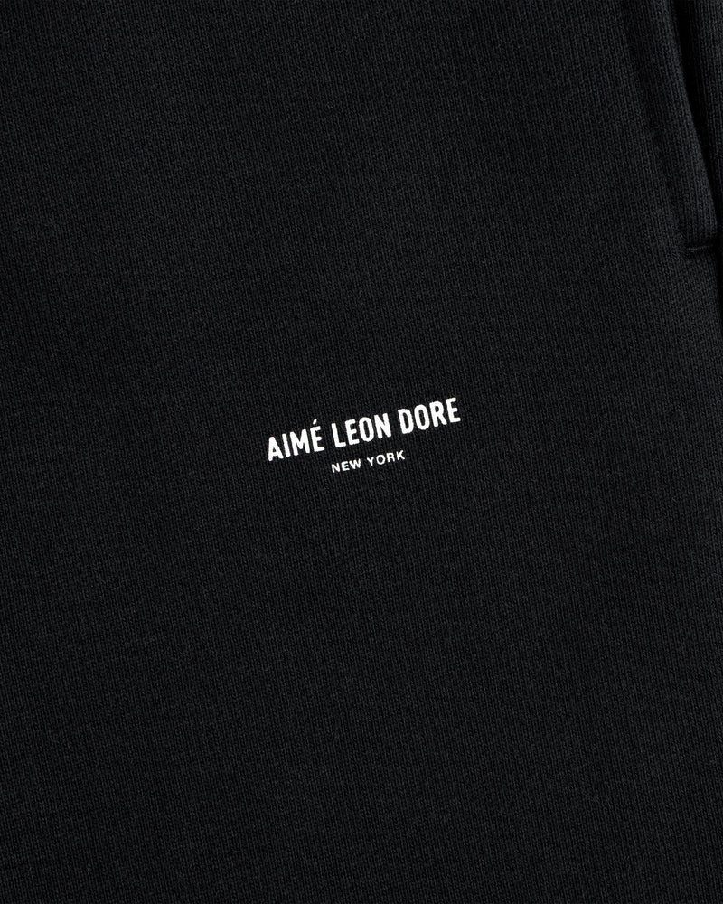 Close-up of black Micro Logo Sweatpants with AIMÉ LEON DORE NEW YORK in small white letters.
