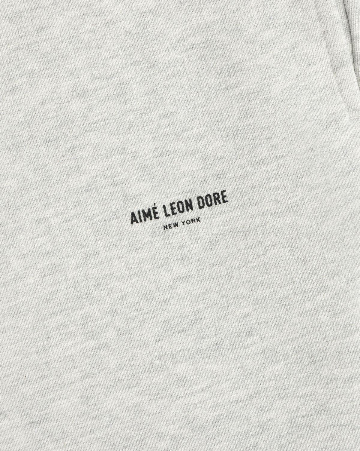 Close-up of light gray Micro Logo Sweatpants with minimalist black AIMÉ LEON DORE NEW YORK print.