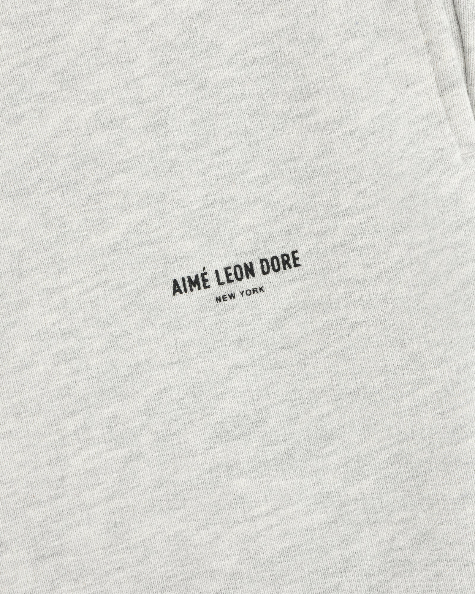 Close-up of light gray Micro Logo Sweatpants with minimalist black AIMÉ LEON DORE NEW YORK print.