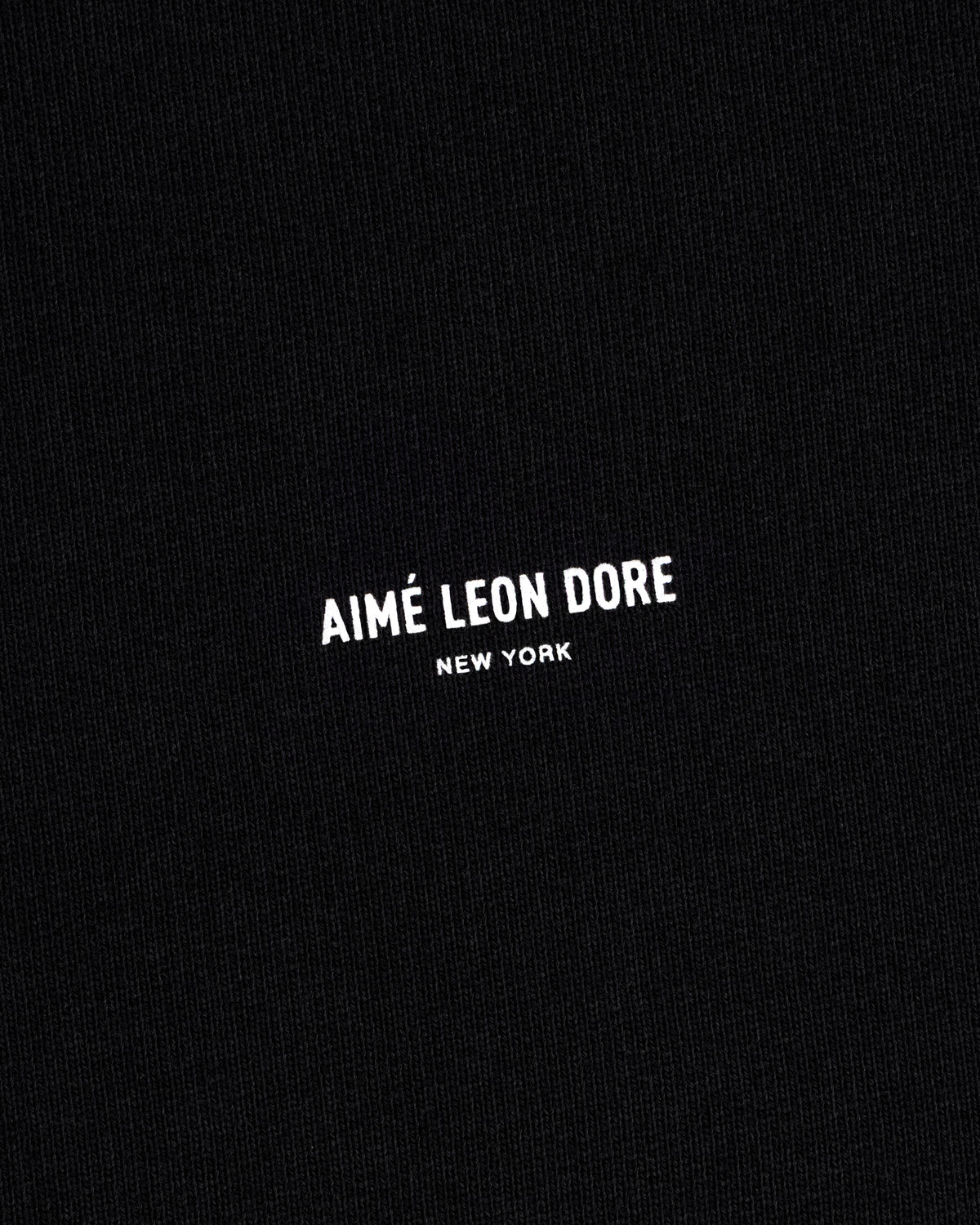 Black Micro Logo Crewneck Sweatshirt with small white Aimé Leon Dore New York print centered on fabric.