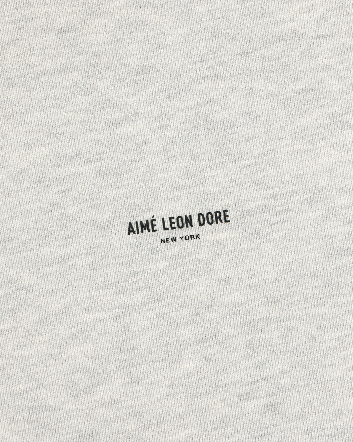 Close-up of gray Micro Logo Crewneck Sweatshirt featuring AIMÉ LEON DORE NEW YORK printed in black at the center.
